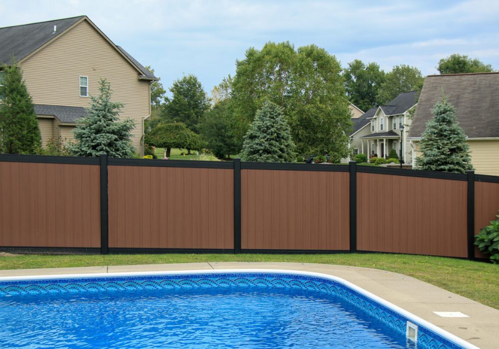 brown vinyl fence panels with black trim around the outside of a pool area