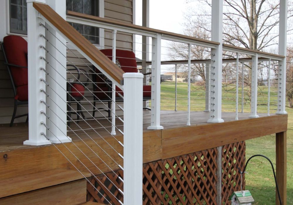 white and faux wood horizontal cable railing wrapped around a front porch