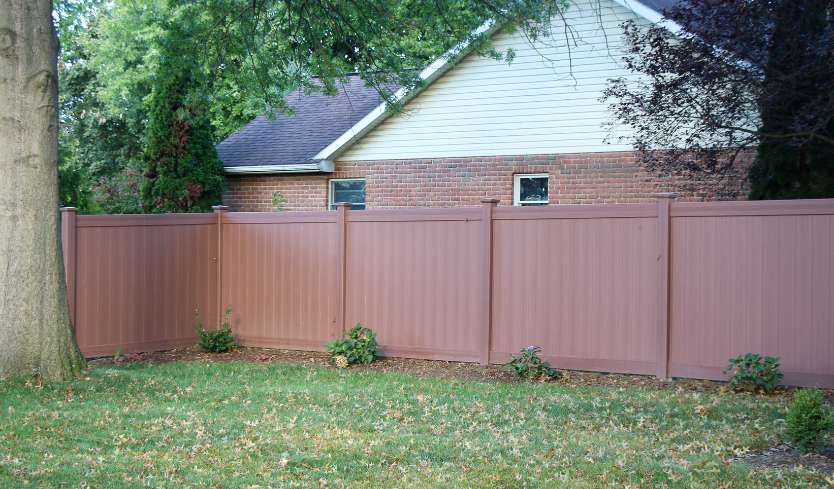 Solid brown vinyl fence that looks like wood grain