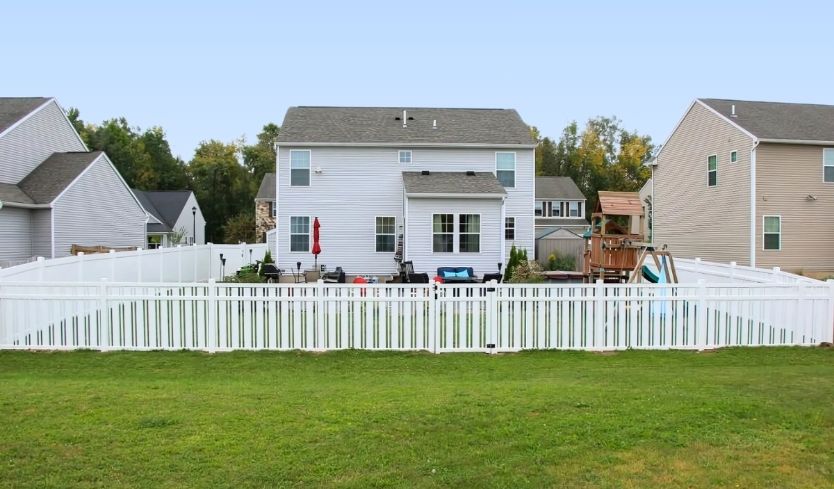 home surrounded by short yard fence in backyard