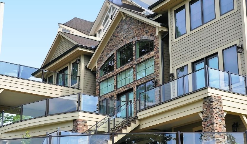 Glass Railing Systems on large home under clear blue sky